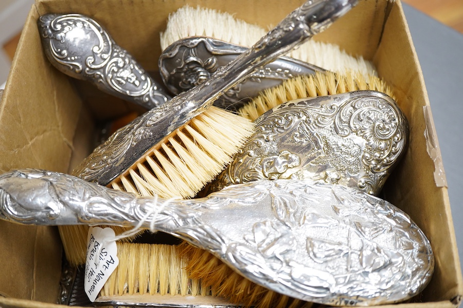 An Edwardian repousse silver mounted six piece dressing table mirror, brush and comb set, by Henry Matthews, Birmingham 1901, together with one other silver mounted hair brush and clothes brush.